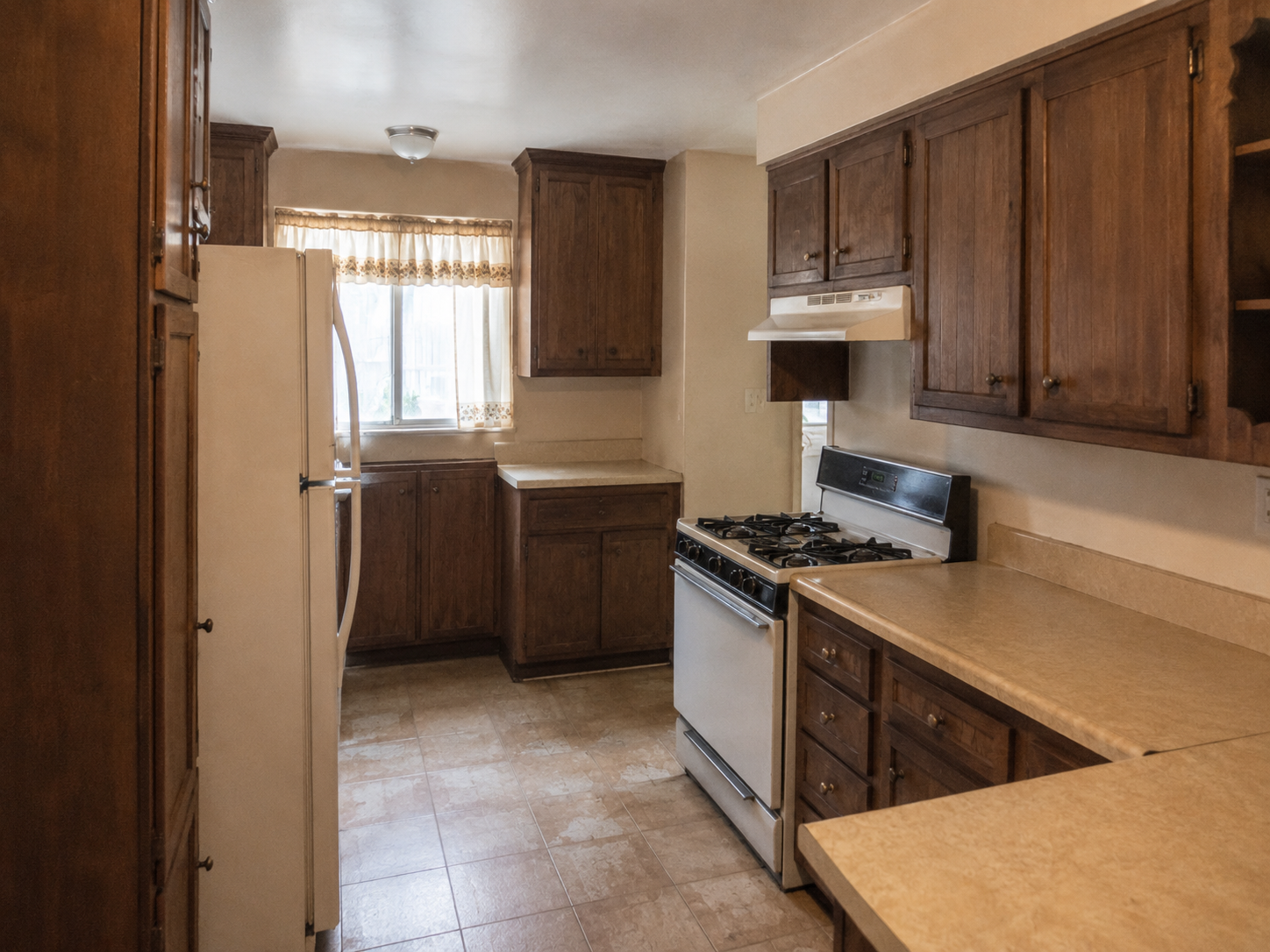 La Puente kitchen before remodel — dark wood cabinets, laminate counters and dated galley layout