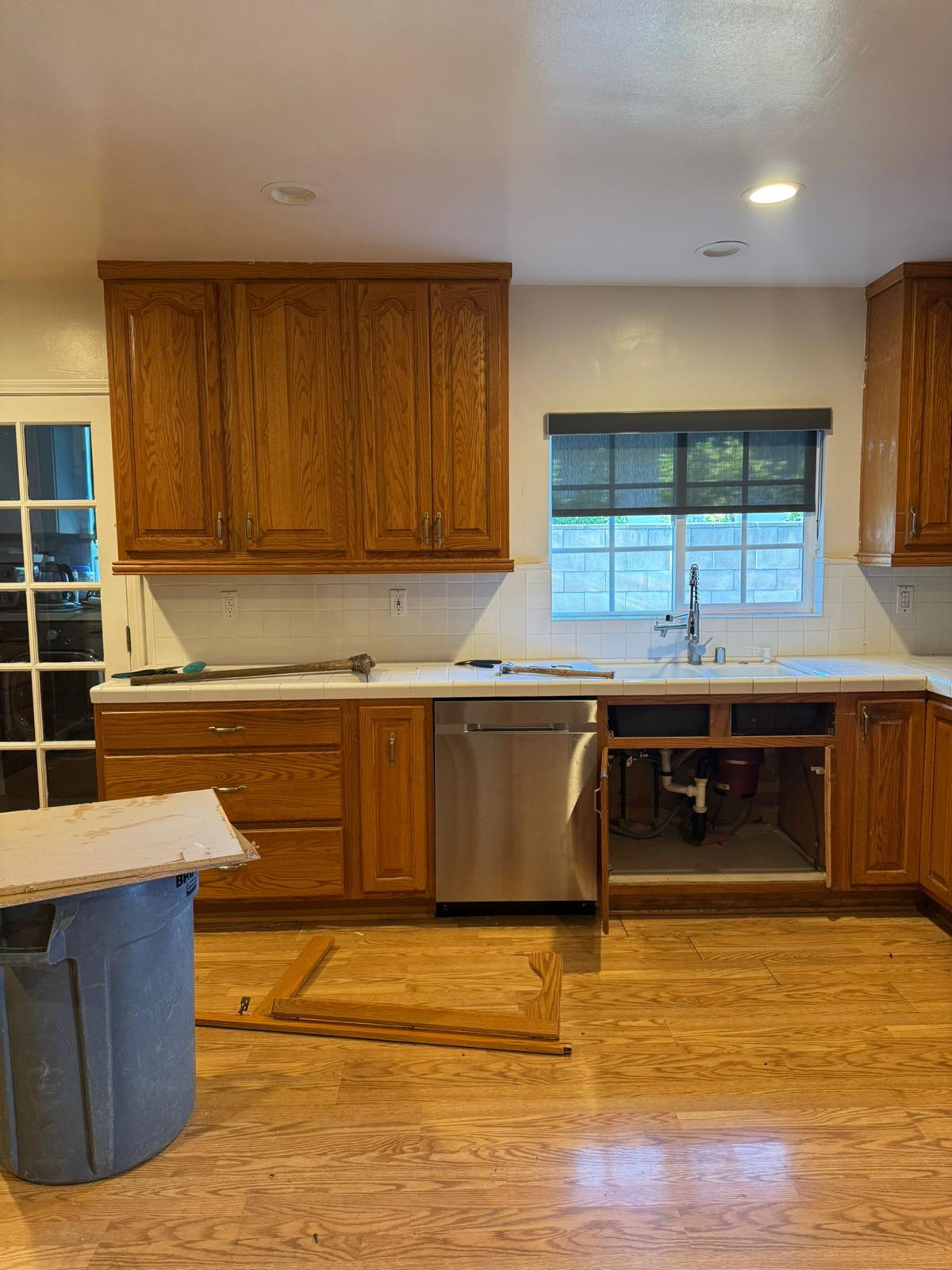 Woodland Hills kitchen mid-demo — original oak cabinetry and tile backsplash before tear-out