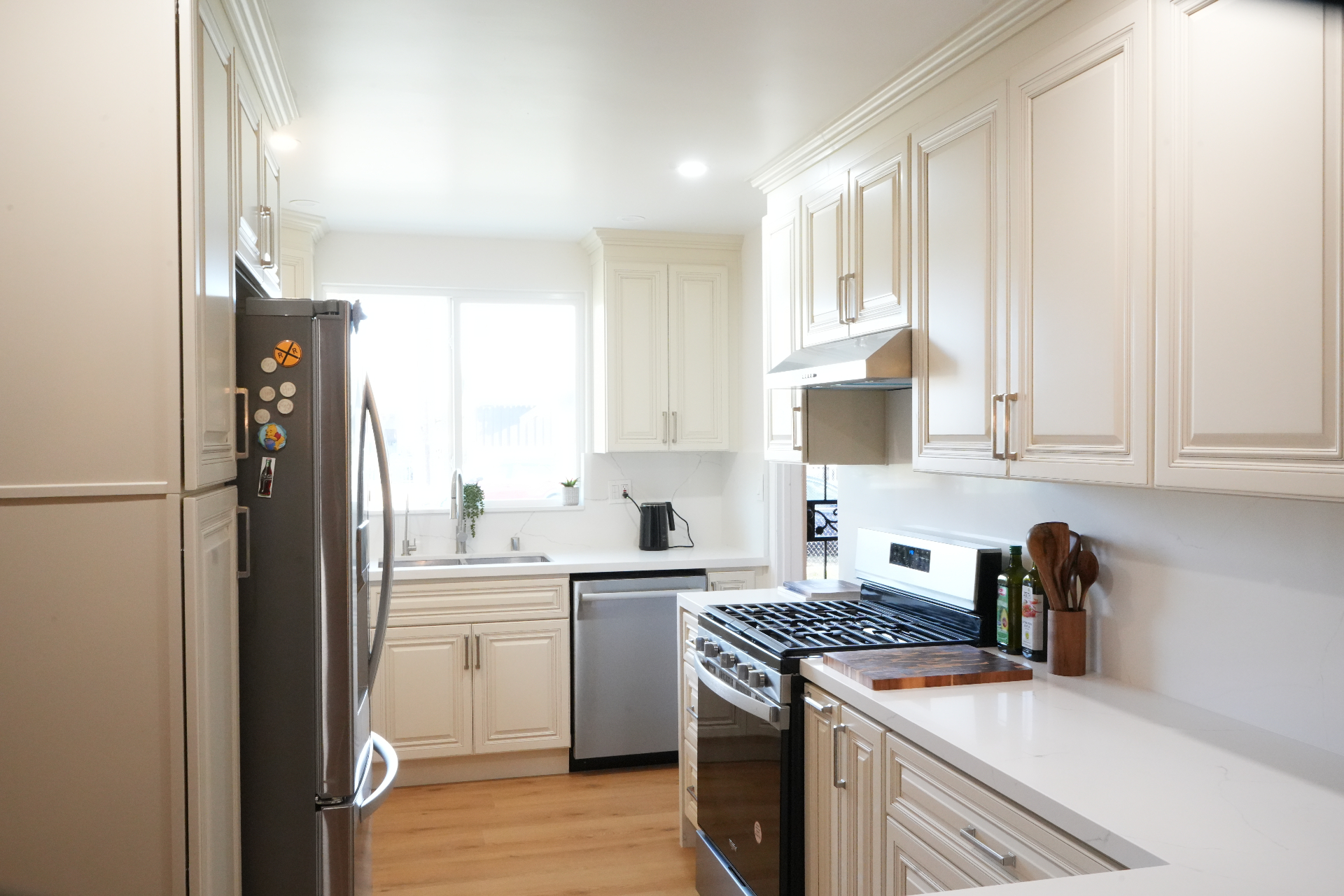 La Puente kitchen after remodel — cream raised-panel cabinets, quartz counters and stainless appliances