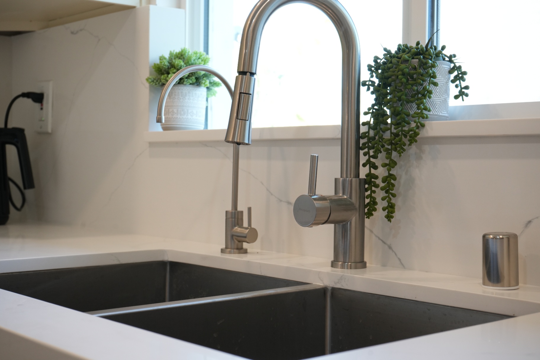 La Puente kitchen sink detail — dual undermount basin with pull-down and filtered faucets