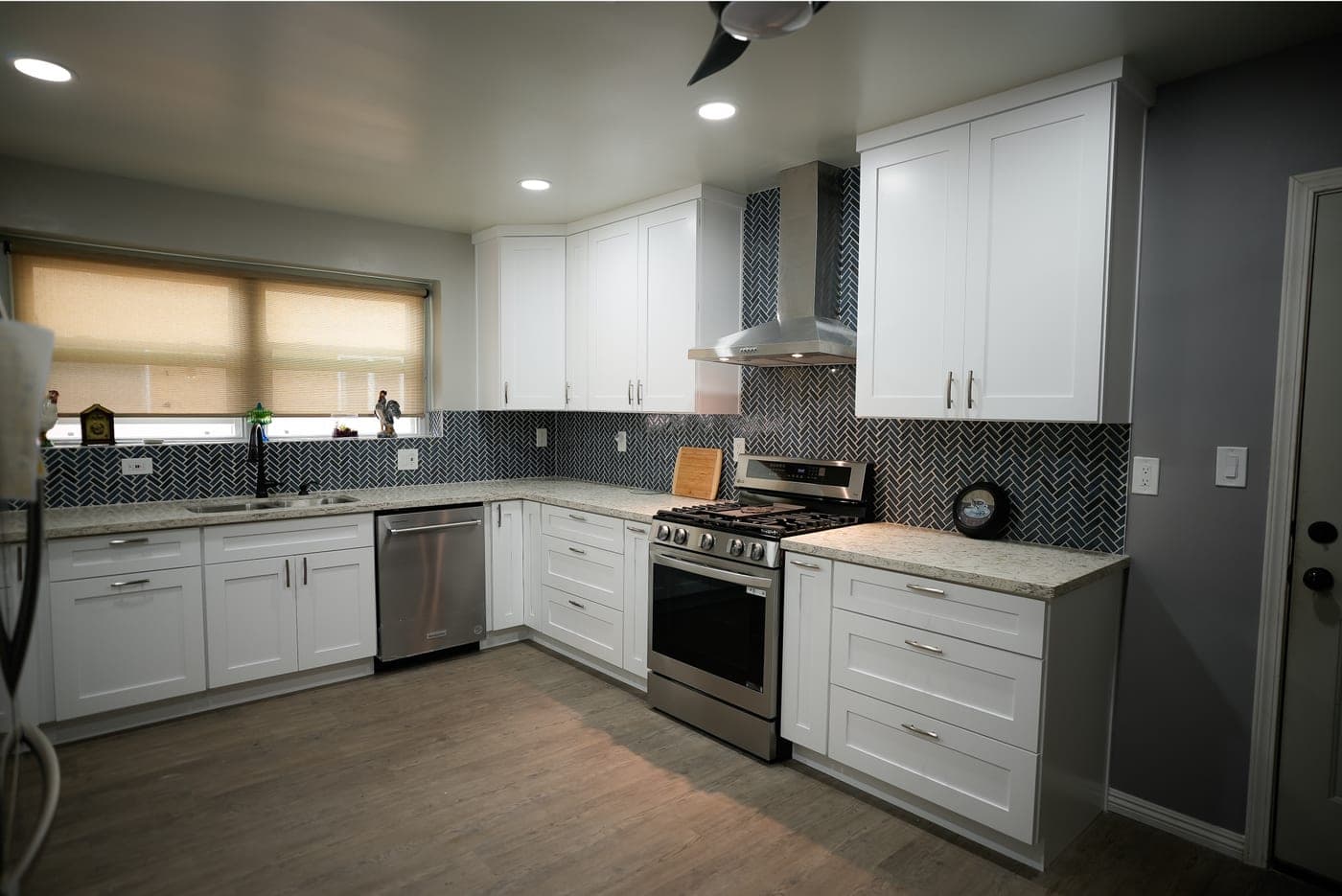 North Hills kitchen with white Shaker cabinetry, quartz counters and a navy herringbone backsplash