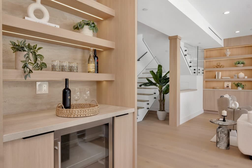 Oak bar with floating shelves, a stone counter and a wine fridge