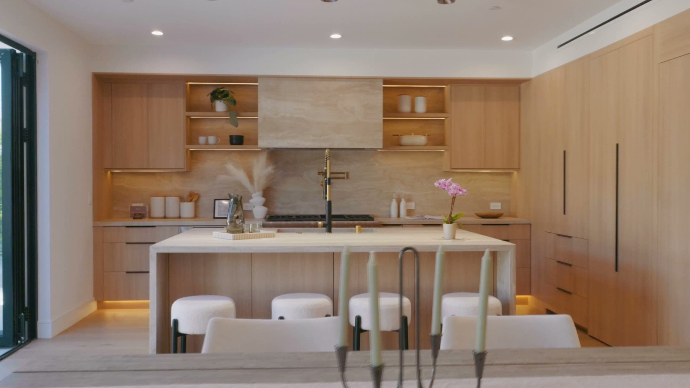 West Hollywood kitchen by Master Kitchen: light oak cabinetry, stone waterfall island and LED-lit shelving